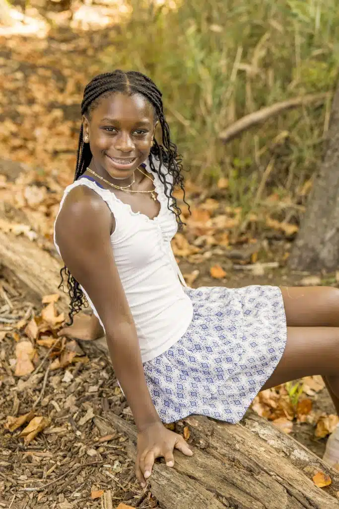 6th grade girl sitting on log