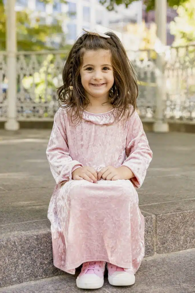 Kindergartener girl sitting on step