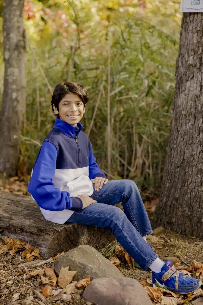 6th grade boy sitting on log